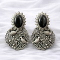 Ornate silver earrings with peacock design