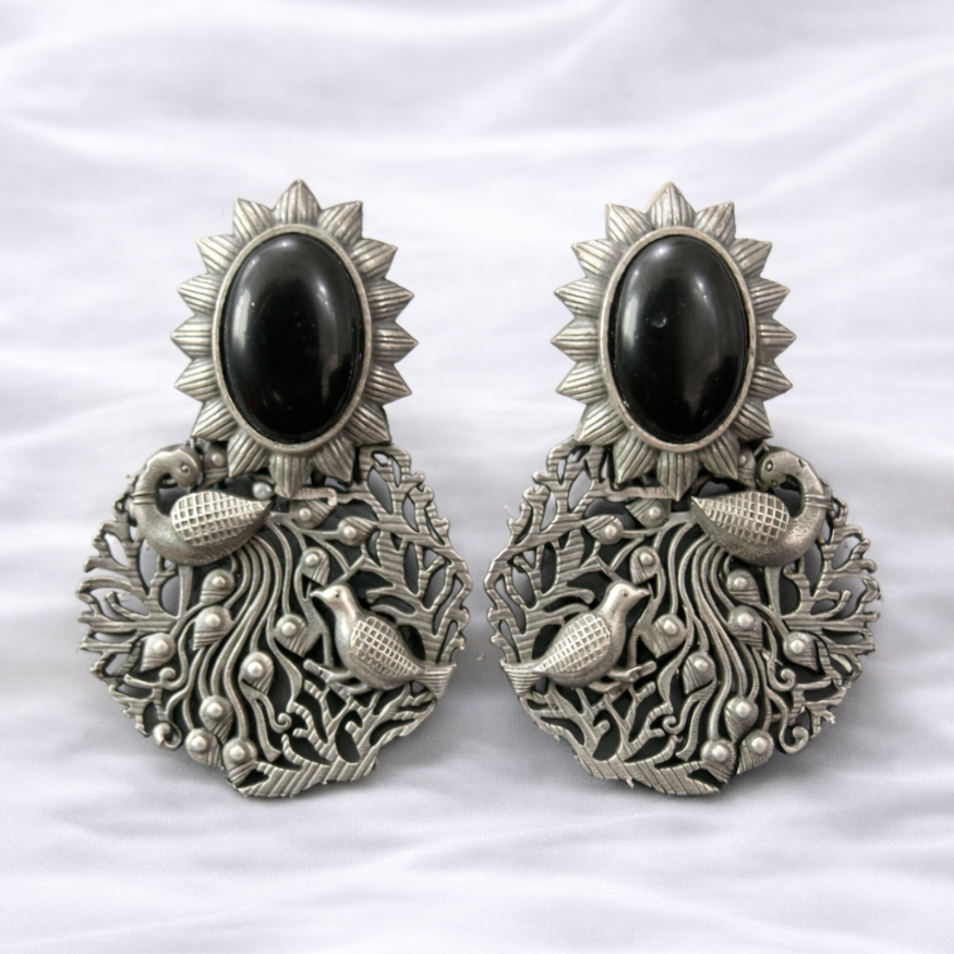 Ornate silver earrings with peacock design