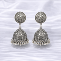 Intricate silver jhumka earrings on fabric