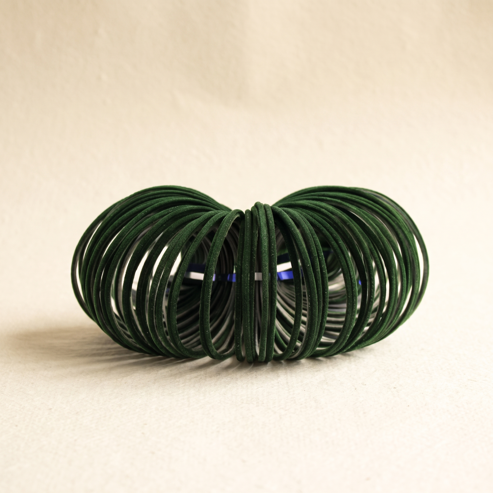 Dark green velvet bangles on warm ivory paper