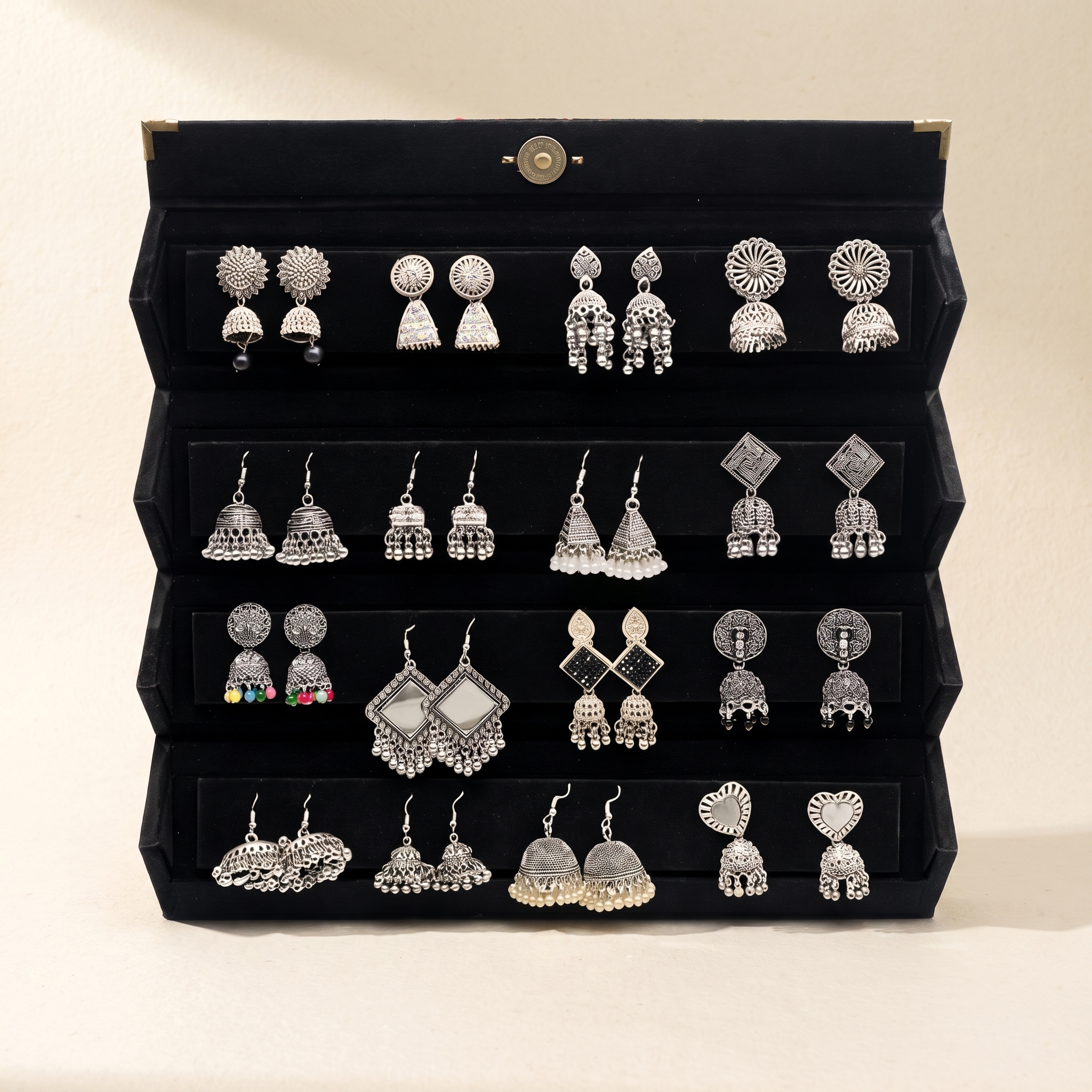 16 pair antique silver jhumka earrings case on warm ivory paper