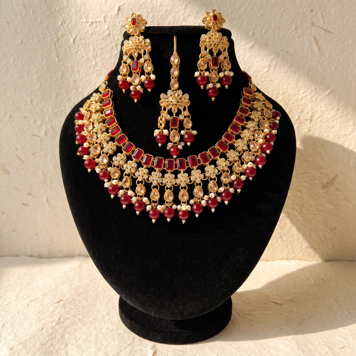 Royal ruby red bridal jewellery set on warm ivory paper