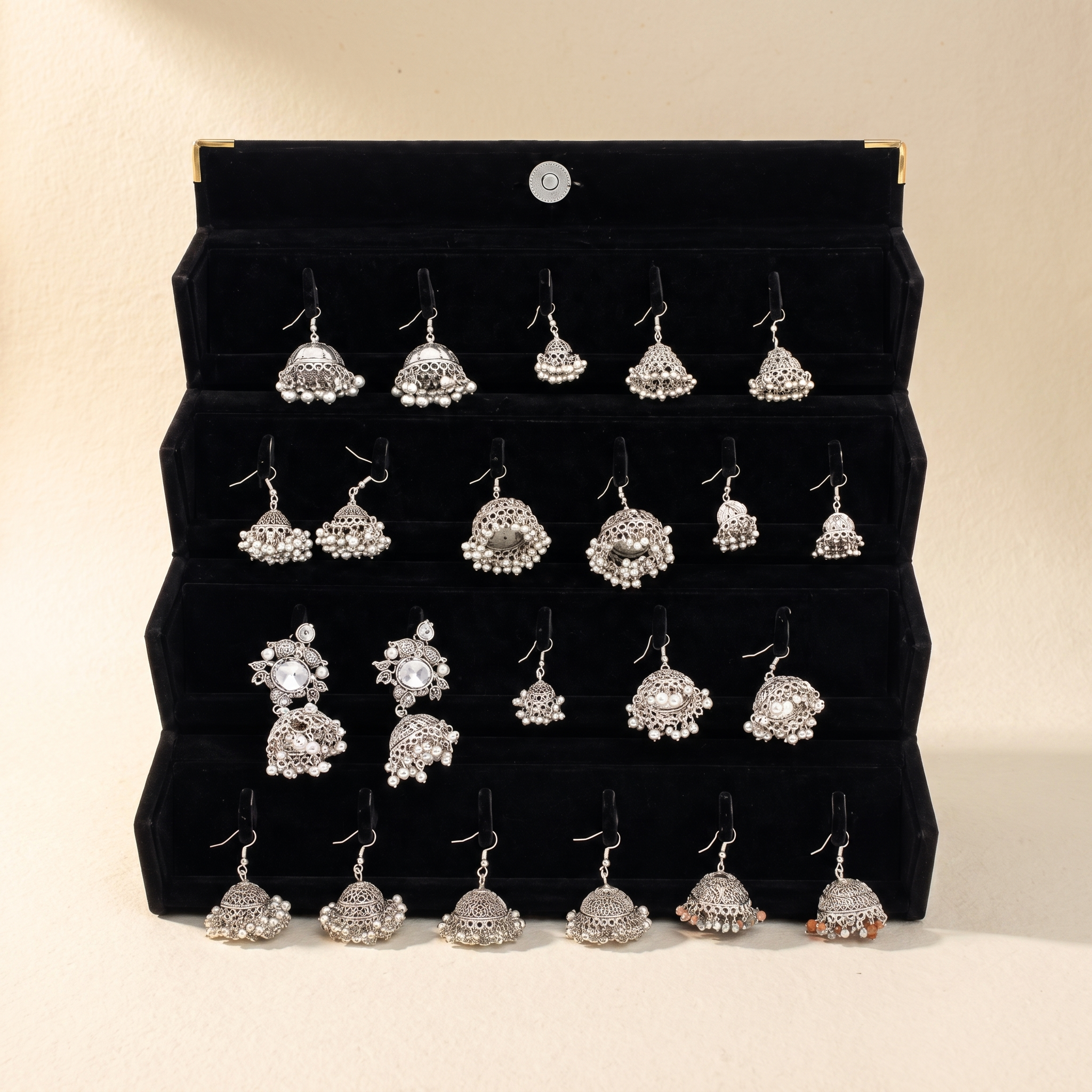 Traditional silver jhumka collection on warm ivory paper